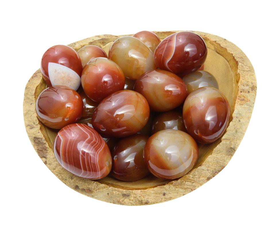 Group of carnelian yoni eggs in a bowl to show color variations.